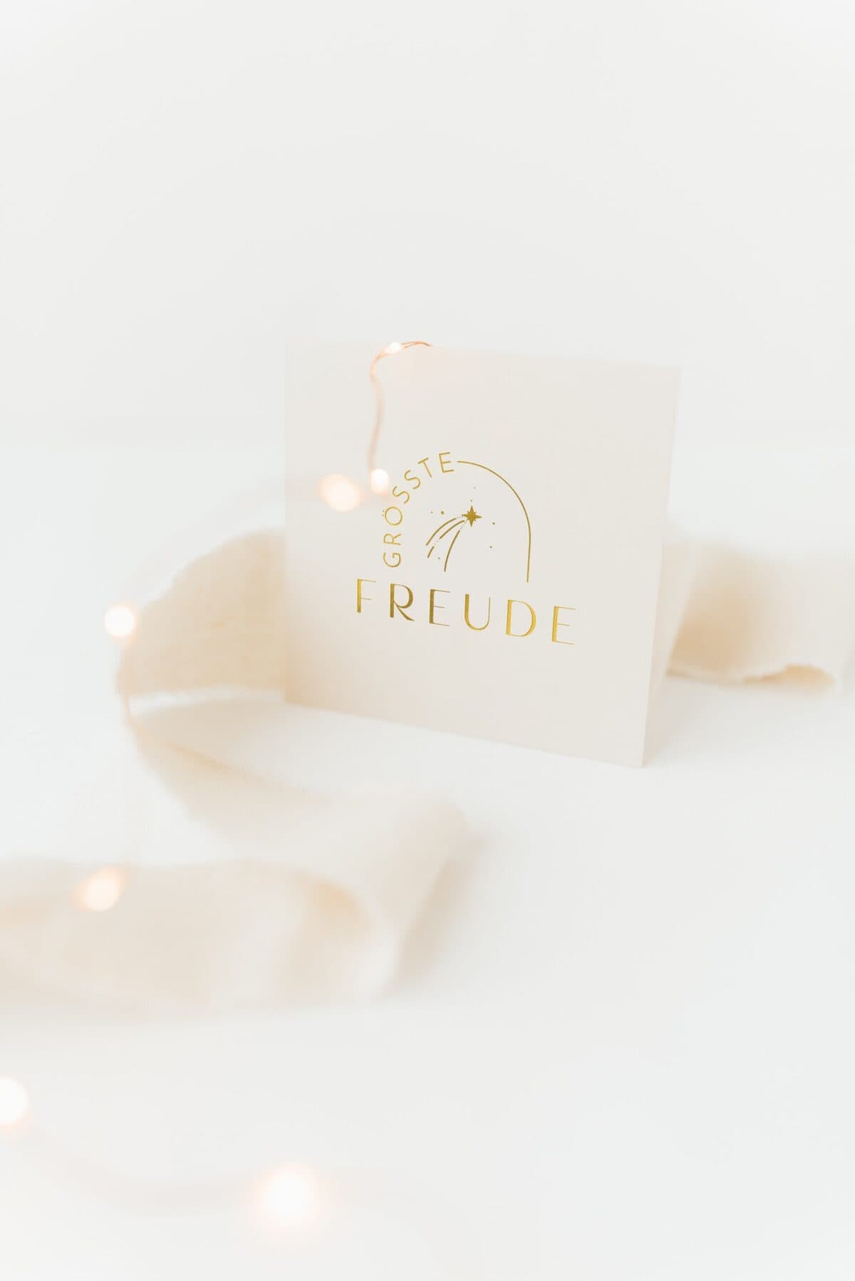 Weihnachtskarte mit goldener Aufschrift und festlicher Dekoration.