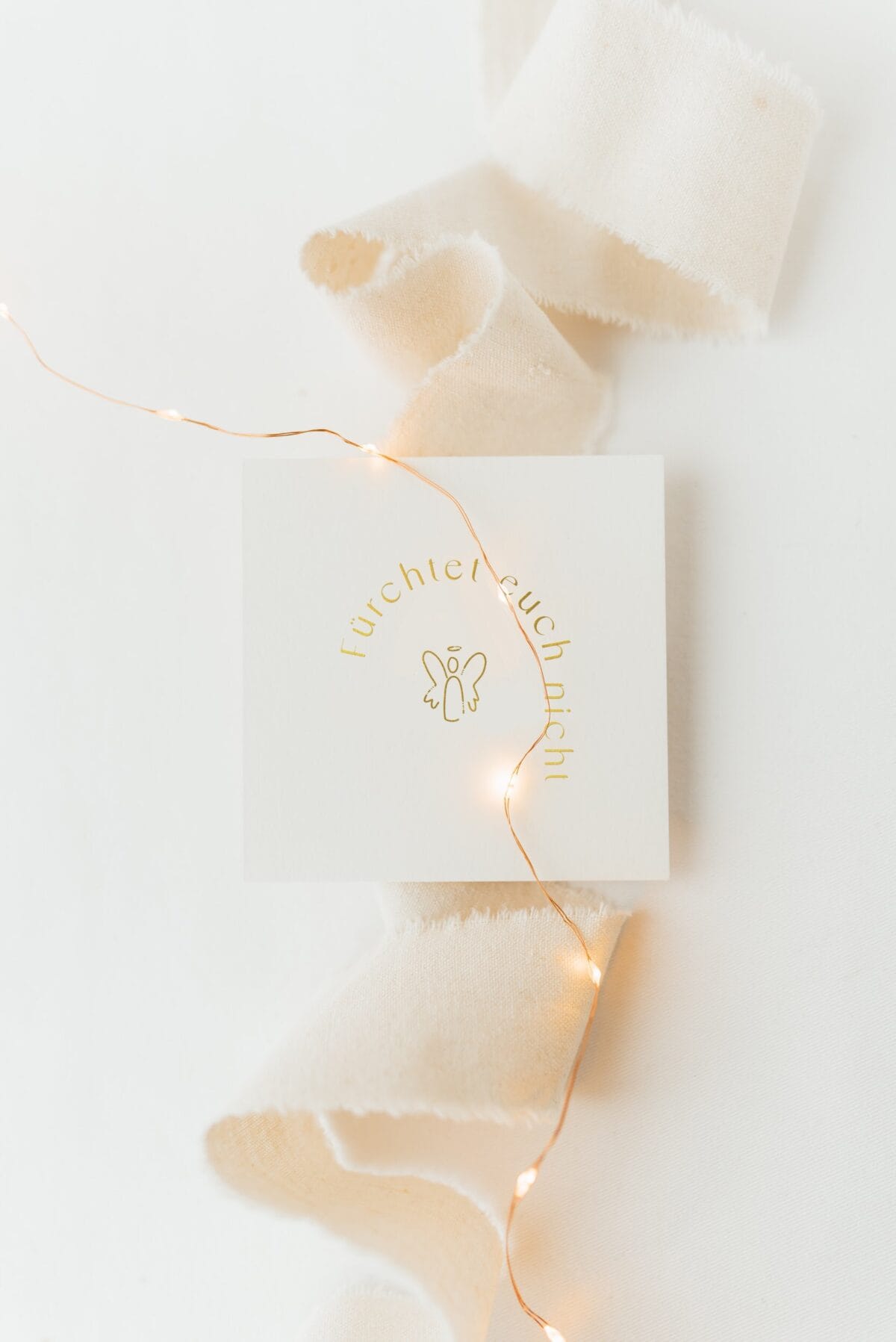 Weihnachtskarte mit Goldmomente-Design und Lichterkette, festliche Stimmung.
