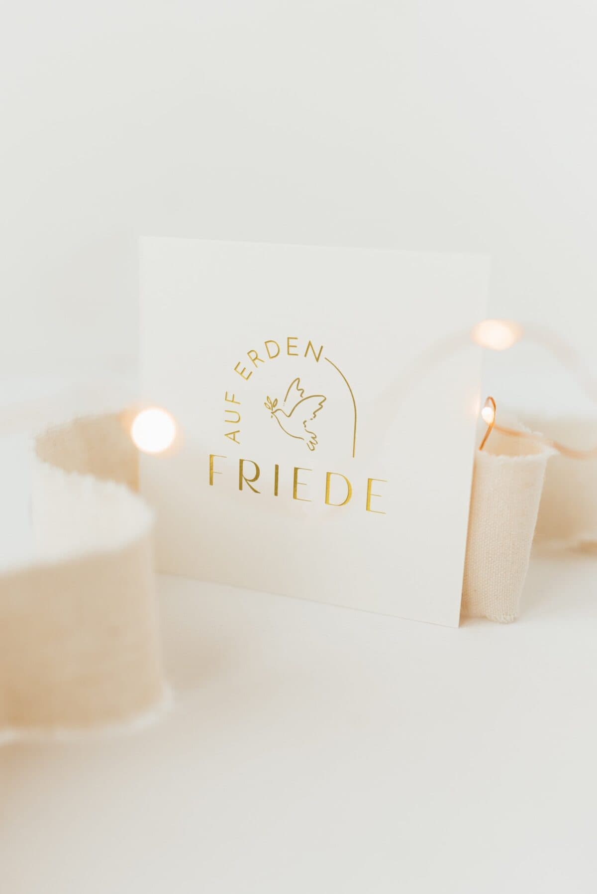 Weihnachtskarte mit goldener Friedens- und Tauben-Design, festliche Stimmung.