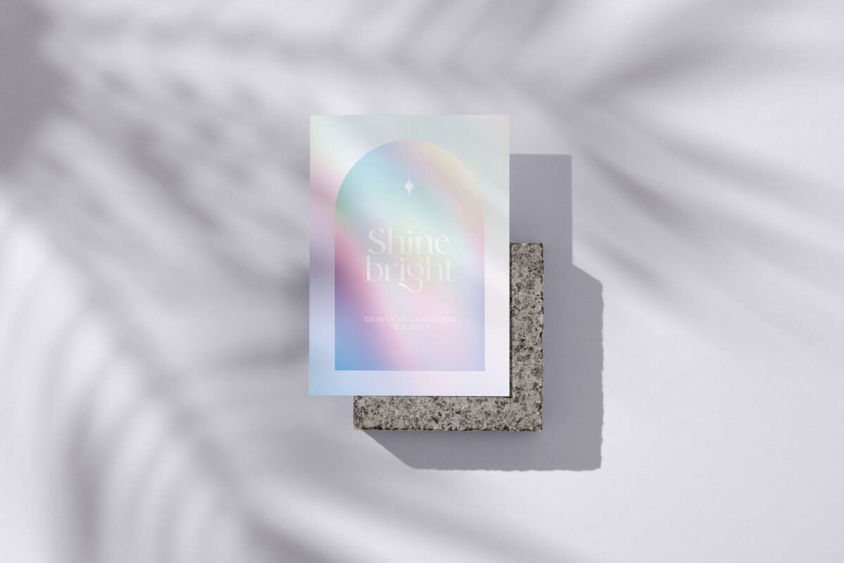 Postkarten-Set mit Regenbogen-Design und inspirierendem Spruch auf grauem Stein.